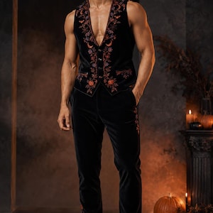 May include: A black velvet vest and matching trousers set featuring intricate orange and purple embroidery of pumpkins, crescent moons, and spiderwebs. The vest has a deep V-neckline with a button-front closure and two front pockets.