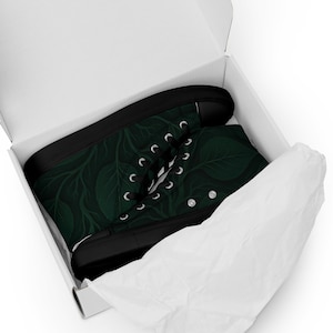 May include: High-top canvas sneakers with a dark green leaf pattern, black soles, and white laces. The shoes are presented in a white box with tissue paper.