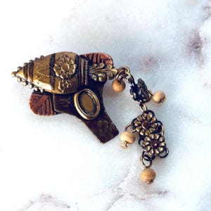 Spilla vintage in metallo misto con pendente floreale, stile boho hippie gipsy, con perline decorative.