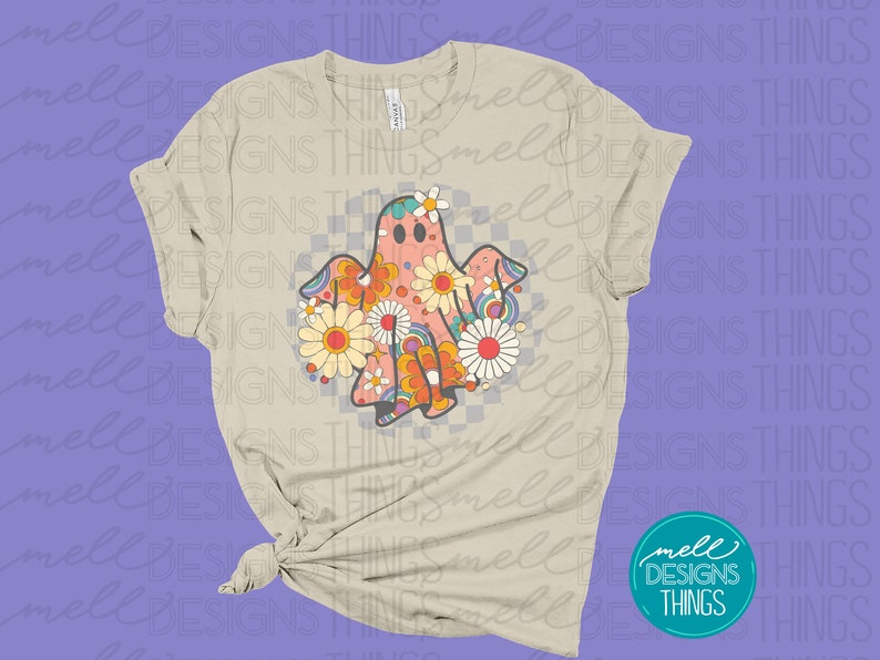 May include: A beige t-shirt with a retro-style ghost design. The ghost is made up of colorful flowers and has a checkered pattern behind it.