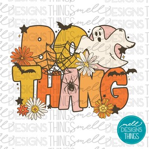 May include: A colorful graphic design with the text "Boo Thing" in a retro style. The design features a ghost, spider web, bats, and flowers in orange, yellow, pink, and green.