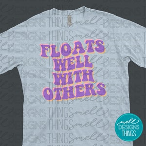 May include: A light blue t-shirt with a purple and orange graphic that says "Floats Well With Others".