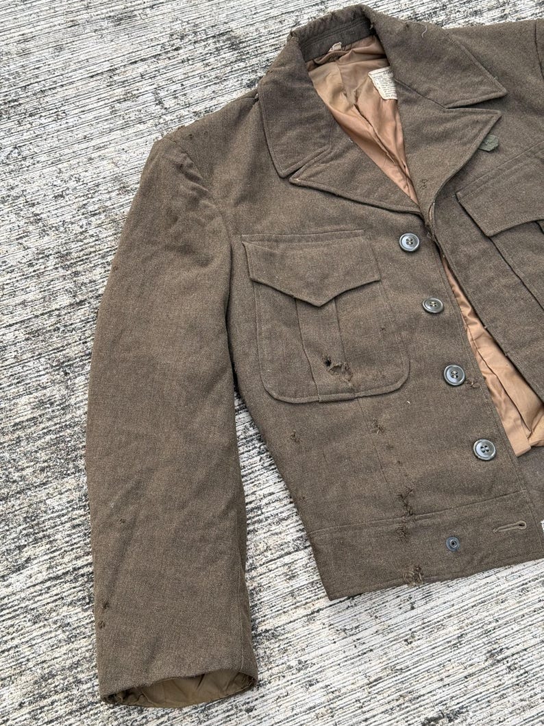 Puede incluir: Chaqueta vintage de lana marr&oacute;n con un dise&ntilde;o cl&aacute;sico. La chaqueta presenta un cuello con solapas, dos bolsillos delanteros y cierres de botones. El forro interior es de color marr&oacute;n claro. La chaqueta muestra signos de desgaste.