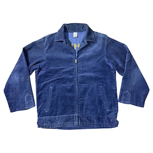 Op de afbeelding: Een blauw corduroy jack met ritssluiting en twee voorzakken. De jas heeft lange mouwen en een kraag. Het woord "H" is in het geel op de borst geborduurd. De jas is van gemiddeld gewicht.