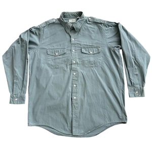 Op de afbeelding: Een lange mouwen, saliegroen button-down shirt met twee borstzakken en schouderstukken. Het shirt heeft een klassieke kraag en manchetten met knopen. Het L.L.Bean-logo is zichtbaar op de kraag.