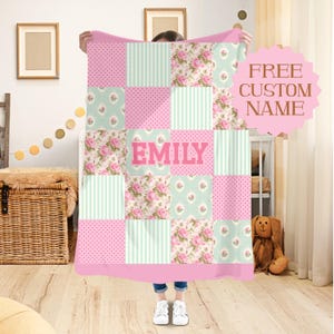 Op de afbeelding: Een patchworkdeken in roze, mintgroen en bloempatronen, met de naam "EMILY" in grote roze letters. De deken heeft een roze rand en de woorden "FREE CUSTOM NAME" zijn zichtbaar.