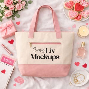 Può includere: Una borsa tote color crema con dettagli rosa, una tasca con cerniera e manici rosa. La borsa presenta il testo "Simply Liv Mockups". L'immagine include anche biscotti a forma di cuore, una confezione regalo e una candela.