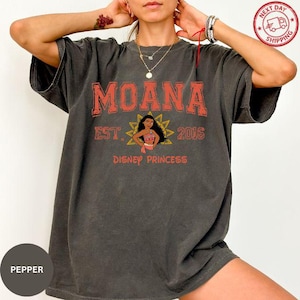 A person wearing a black t-shirt with the text "Moana" and "Disney Princess" printed on it.
