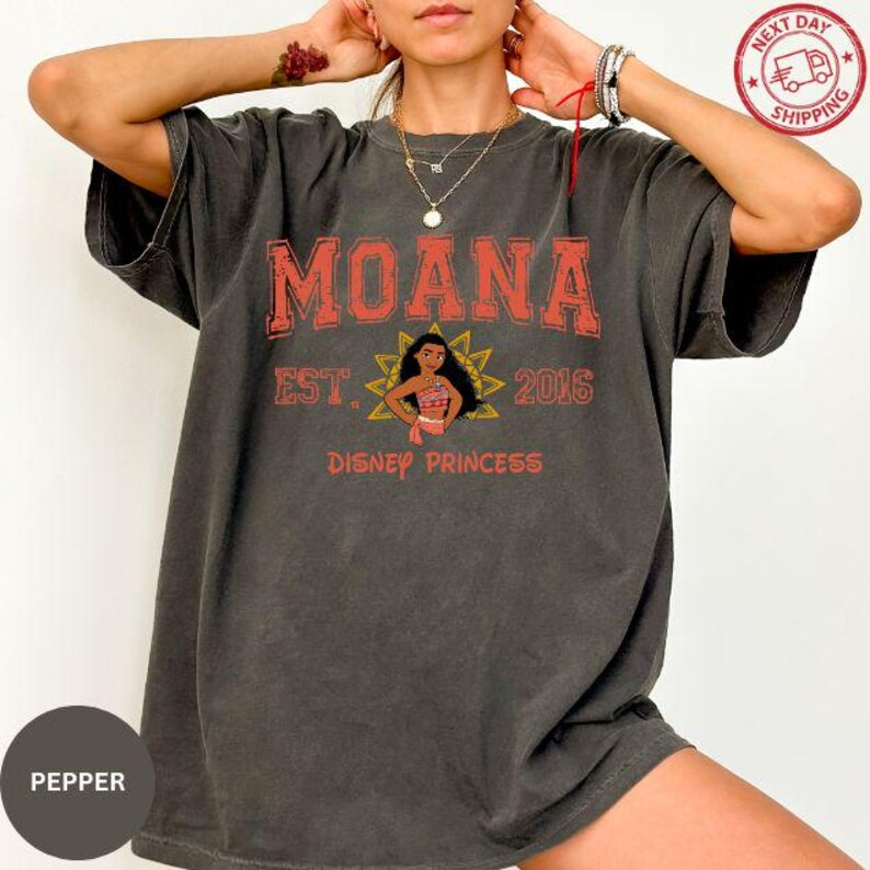 A person wearing a black t-shirt with the text "Moana" and "Disney Princess" printed on it.