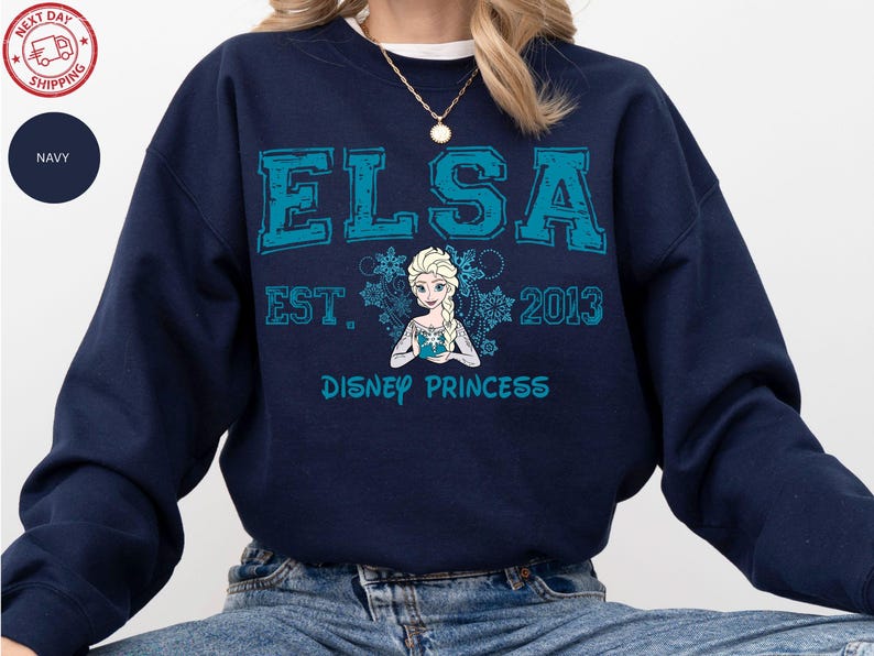 A navy blue sweatshirt with a graphic design featuring the character Elsa from the Disney movie Frozen.