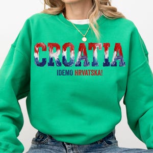 A person wearing a green sweatshirt with the word "Croatia" printed on it.