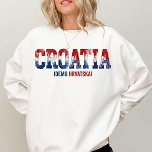 A woman wearing a white sweatshirt with the text "Croatia" printed on it.