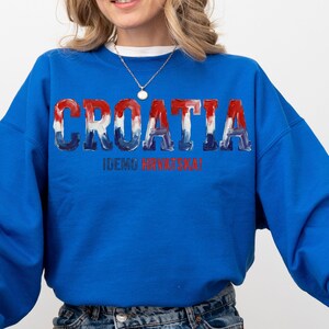 A woman wearing a blue sweatshirt with the word "Croatia" printed on it.