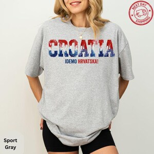 A woman wearing a grey t-shirt with the word "Croatia" printed on it.