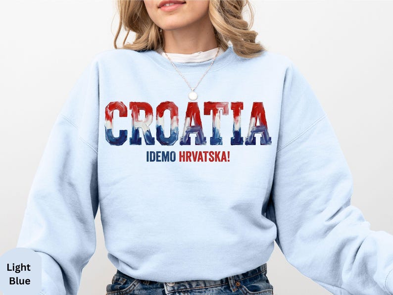 A woman wearing a light blue sweatshirt with the word "Croatia" printed on it.