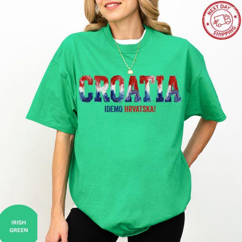 A woman wearing a green t-shirt with the text "Croatia" and "IDEMO HRVATSKA!" printed on it.