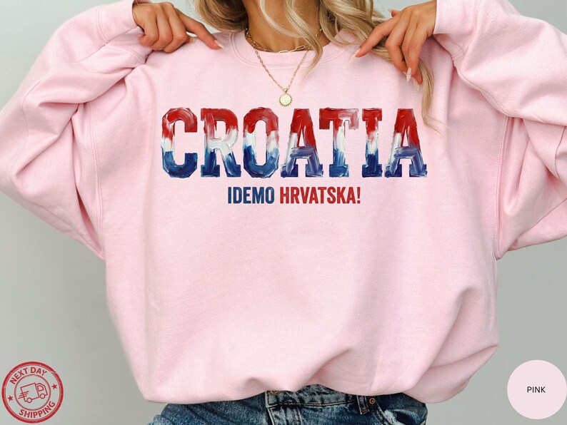 A person wearing a pink sweatshirt with the word "Croatia" printed on it.