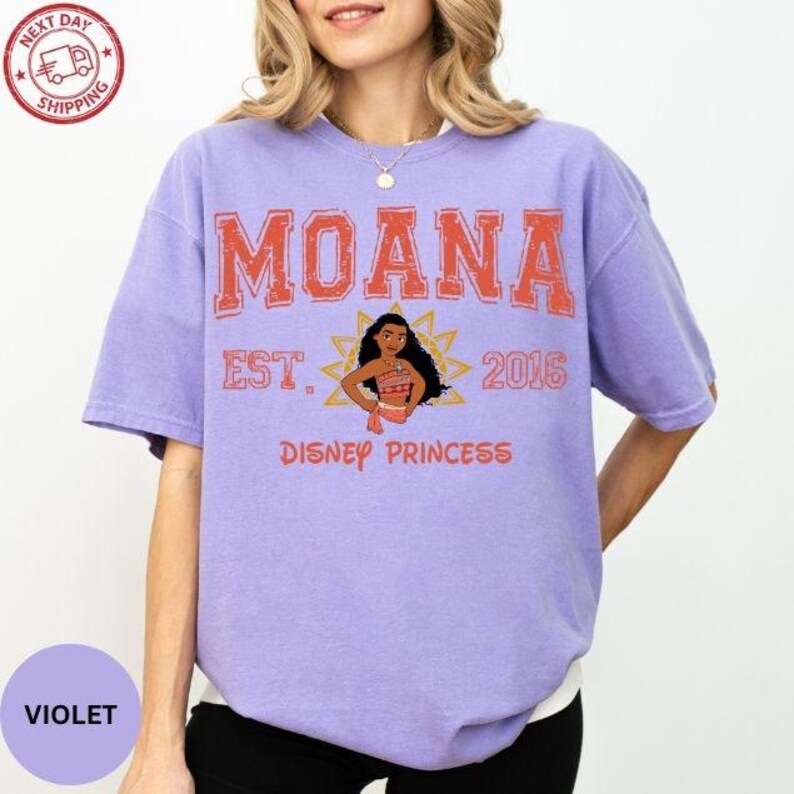A woman wearing a purple t-shirt with the text "Moana Est. 2016 Disney Princess" printed on it.