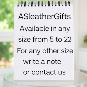 Puede incluir: Un bloc de notas blanco con encuadernaci&oacute;n en espiral y texto negro que dice: ASleatherGifts Available in any size from 5 to 22 For any other size write a note or contact us. El bloc est&aacute; colocado verticalmente sobre una superficie de cristal.