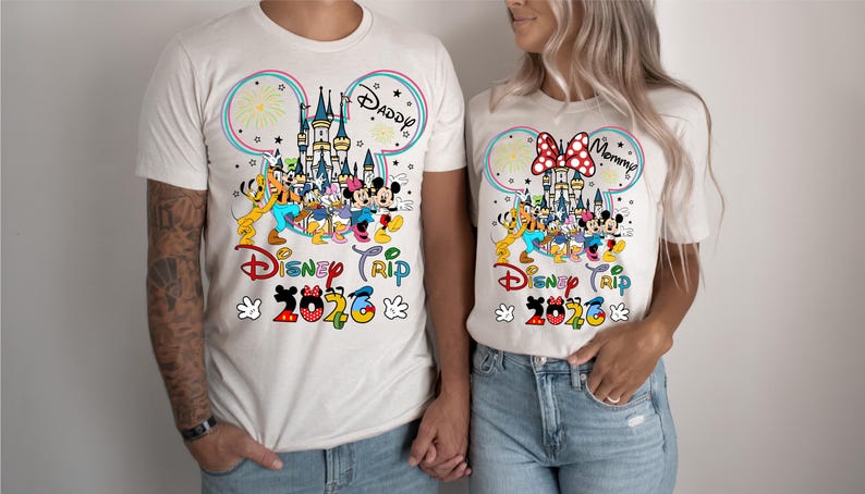 Puede incluir: Camisetas beige a juego con un colorido dise&ntilde;o de Disney. El dise&ntilde;o incluye un castillo, fuegos artificiales y personajes de Disney. El texto "Disney Trip 2020" se muestra debajo. Una camiseta dice "Daddy" y la otra dice "Mommy".