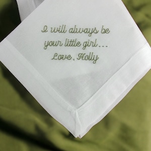 May include: White handkerchief with green embroidered text that reads "I will always be your little girl... Love, Holly"