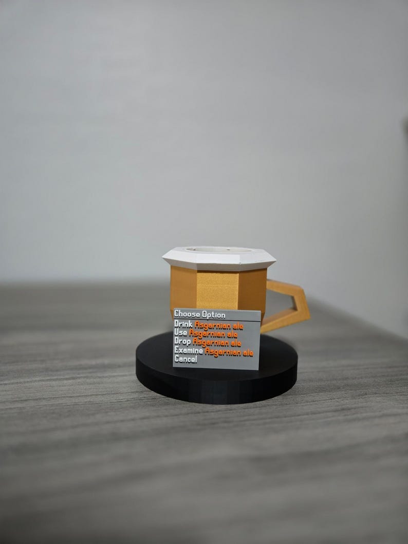 May include: A gold-coloured, geometric mug with a white top and a black base. A small grey rectangle displays the text "Choose Option" and other lines of text in orange. The mug has a unique handle design.