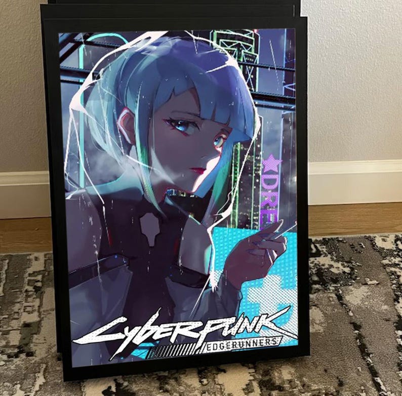 K&ouml;nnte beinhalten: Ein gerahmtes Poster mit einer Cyberpunk-Anime-Illustration. Das Kunstwerk zeigt eine weibliche Figur mit blau-gr&uuml;nen Haaren vor einer futuristischen Stadtlandschaft. Das Poster enth&auml;lt den Text "Cyberpunk Edgerunners" in einer stilisierten Schriftart, in einem schwarzen Rahmen.