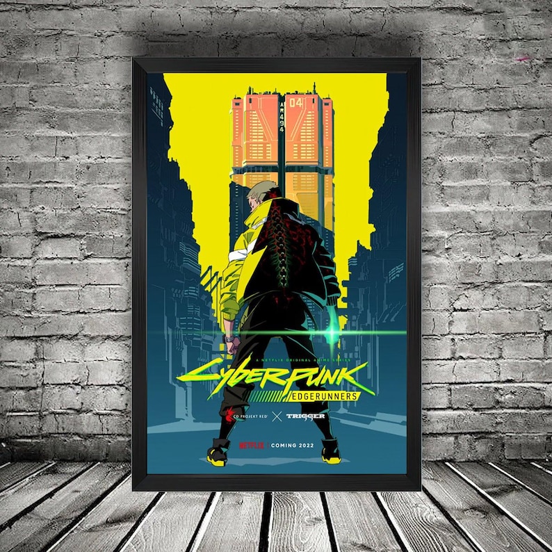K&ouml;nnte beinhalten: Gerahmtes Poster mit einem Charakter aus Cyberpunk: Edgerunners in einer futuristischen Stadt. Das Poster hat ein gelbes und blaues Farbschema mit dem Titel und Logo der Serie. Der Text "COMING 2022" befindet sich unten.