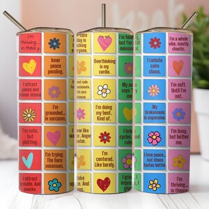 May include: Three colorful 20 oz. stainless steel tumblers with straws. Each tumbler is covered in a grid of squares with phrases like "I'm thriving in theory" and "Overthinking is my cardio" with flower and heart graphics.