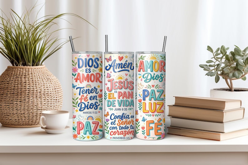 Pu&ograve; includere: Tre bicchieri cilindrici in metallo con cannucce, ciascuno caratterizzato da testi religiosi colorati e illustrazioni floreali. I design includono frasi come Dios es Amor, Amen, Jesus es el Pan de Vida, Amor Dios, Paz, Luz e Fe in vari caratteri.