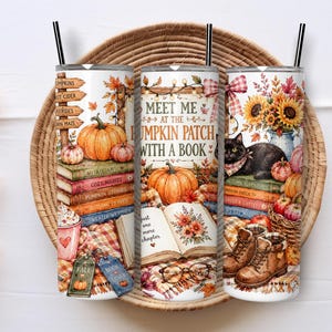 May include: Three cylindrical tumblers with black straws featuring a fall-themed design. The print includes pumpkins, stacks of books, a black cat, sunflowers, and the text 'MEET ME AT THE PUMPKIN PATCH WITH A BOOK' alongside cosy autumn imagery.