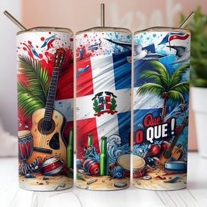 Op de afbeelding: Drie roestvrijstalen bekers met rietjes, elk met ontwerpen met het thema Dominicaanse Republiek. Elke beker toont de Dominicaanse vlag, muziekinstrumenten, palmbomen en de zin "Que Lo Que!" in een kleurrijke illustratie.
