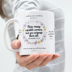 May include: White ceramic mug featuring a floral wreath design with the text "There many capable women, but you surpass them all." Additional text includes Bible verses. A perfect gift for any occasion.