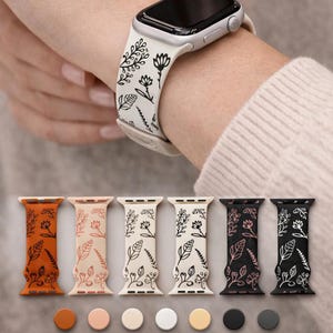 May include: A collection of six silicone watch bands featuring a black botanical line art pattern. The bands are available in orange, light pink, cream, white, yellow, black, and dark gray, with matching circular color swatches shown below.