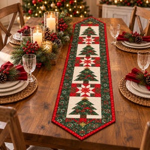 May include: A long, rectangular quilted table runner featuring a repeating pattern of green Christmas trees and white star motifs on a cream background, bordered by a dark green fabric with a small red and white floral print and red trim.
