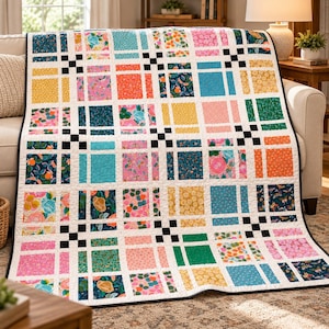 May include: A patchwork quilt featuring a grid of colorful fabric squares with various floral, fruit, and geometric patterns. The design includes white sashing strips and small black square accents at the intersections of the grid.