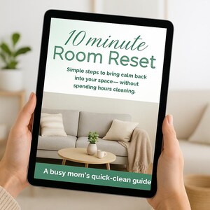 以下が含まれることがあります： タブレットには「10 minute Room Reset」の文字とリビングルームの写真が表示されています。テキストは、掃除に何時間も費やすことなく、空間に落ち着きを取り戻すための簡単なステップを約束しています。このガイドは、忙しいお母さんのためのものです。