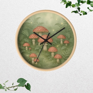 Puede incluir: Reloj de pared redondo con marco de madera clara. La esfera del reloj presenta una ilustración caprichosa de setas rojas y blancas con lunares en un entorno forestal verde. Las manecillas negras indican la hora.