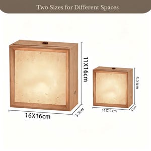 Puede incluir: Dos cajas de luz cuadradas de madera con un panel frontal brillante. La caja m&aacute;s grande mide 16x16x5,5cm y 11x16cm, mientras que la m&aacute;s peque&ntilde;a mide 11x11x5,5cm. Cada caja tiene un peque&ntilde;o pomo oscuro arriba y el texto Two Sizes for Different Spaces.