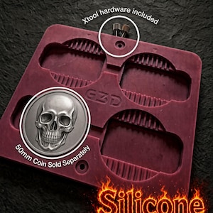 Puede incluir: Un molde de silicona granate con cuatro cavidades rectangulares de bordes estriados y el texto GZD. El molde incluye herrajes Xtool. Un recuadro circular muestra una moneda de plata con una calavera y el texto 50mm Coin Sold Separately. Texto: Silicone Won't Melt.