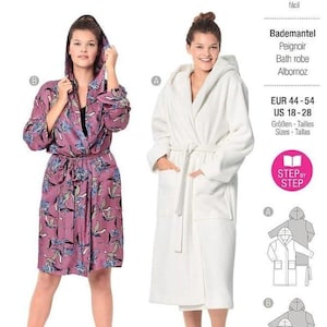May include: A Burda Style sewing pattern 6094 for a hooded bath robe in sizes EUR 44-54. The pattern features two variations: a floral print robe and a solid white robe, both with long sleeves, a tie waist, and front pockets.