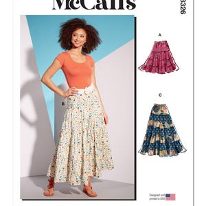 May include: McCall's M8326 sewing pattern featuring a woman wearing a tiered floral skirt and an orange top. The pattern includes illustrations of two skirt designs. The text "Designed and printed in USA" is visible.