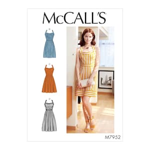 May include: McCall's sewing pattern M7952 featuring a woman in a yellow and white striped dress. The pattern includes illustrations of three additional dress designs: a denim dress, an orange dress, and a black and white polka dot dress.
