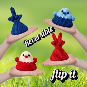 May include: Four handmade, reversible crochet figures in blue, red, and white, with the text "Reversible" and "flip it". The figures have different shapes, including a bird-like design and a hand gesture.