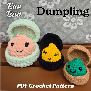 May include: Three crocheted plush toys shaped like open containers with faces, labeled Bao Bun Dumpling PDF Crochet Pattern. The left toy is mint green with a peach center, the middle is black with a yellow center, and the right is tan with a green center.