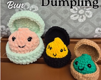 May include: Three crocheted plush toys shaped like open containers with faces, labeled Bao Bun Dumpling PDF Crochet Pattern. The left toy is mint green with a peach center, the middle is black with a yellow center, and the right is tan with a green center.