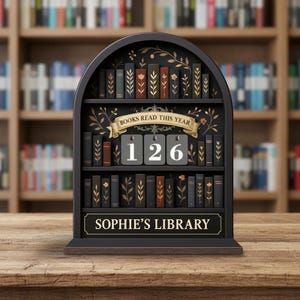 May include: A black wooden bookshelf-shaped display with the text "BOOKS READ THIS YEAR" and the number "126". The bottom of the display reads "SOPHIE'S LIBRARY". The shelves are filled with miniature book replicas.