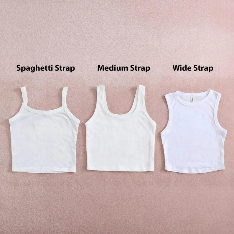 Peut inclure: Trois d&eacute;bardeurs blancs avec diff&eacute;rents styles de bretelles : fines, moyennes et larges. Les hauts sont pr&eacute;sent&eacute;s sur un fond rose, avec les styles de bretelles &eacute;tiquet&eacute;s au-dessus de chacun.