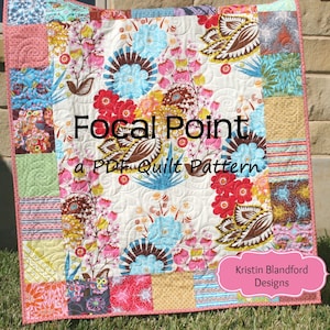 Può includere: Una trapunta colorata con un motivo floreale e un bordo rosa. La trapunta è etichettata "Focal Point a PDF Quilt Pattern" e "Kristin Blandford Designs".