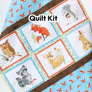 May include: Quilt kit featuring a woodland theme with a variety of animals including a fox, owl, deer, raccoon, squirrel, and rabbit. The quilt is made with a blue and brown fabric with a fox print. The text "Quilt Kit" is visible in the image.